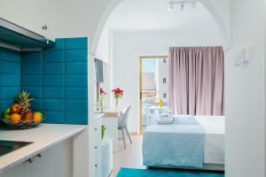 una cocina con azulejos azules y una cama en una habitación en Stephanie Studios en Lárnaca