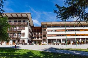 an apartment building with a courtyard in front of it at La Gregoriana in Auronzo di Cadore