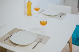 a white table topped with a white plate and a white bowl at Stephanie Studios in Larnaca