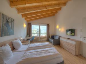 duża sypialnia z 2 łóżkami i kanapą w obiekcie Residenz Kitzsteinhornblick by Kaprun Rentals w Kaprunie