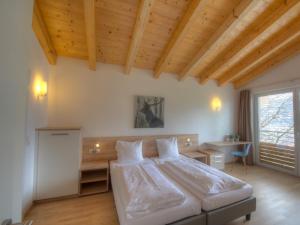 a bedroom with a large bed and a desk at Residenz Kitzsteinhornblick by Kaprun Rentals in Kaprun