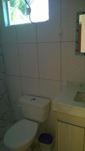uma casa de banho com um WC, um lavatório e uma janela em Casa em Imbassai em Imbassaí