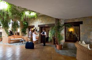 a man and woman shaking hands in a lobby at Hotel & SPA des Pecheurs in Bonifacio