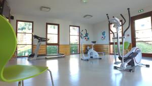 un gimnasio con varias bicicletas estáticas en una habitación en VVF Les Fontaines des Vosges, en Saales