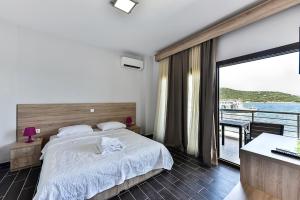 a bedroom with a bed and a view of the ocean at Pension Limani in Ammouliani
