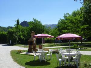 un grupo de mesas y sillas con sombrillas en Camping Notre Dame, en Castellane