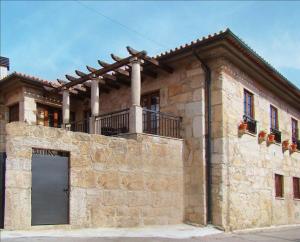 un edificio de piedra con balcón en la parte superior. en Casa de Campo Patio do Avo, en Routar