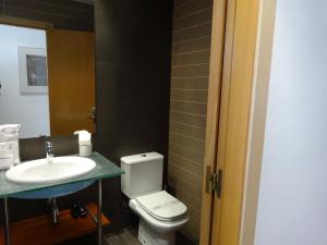 a bathroom with a white toilet and a sink at Fisa Rentals Shopping in Barcelona