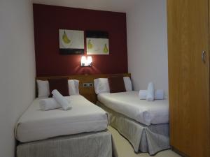 バルセロナにあるFisa Rentals Shoppingのホテルルーム 白いシーツ付きのベッド2台付