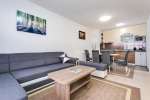a living room with a couch and a table and a kitchen at Apartment Nova Cesta 62 in Zagreb