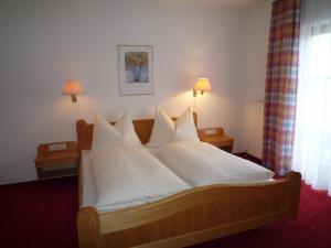 1 dormitorio con 1 cama con sábanas y almohadas blancas en Appartement Bergkristall, en Sankt Johann im Pongau