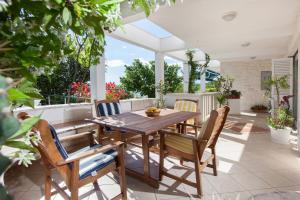 a patio with a wooden table and chairs at Villa Noa in Makarska