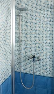 a shower in a bathroom with blue and white tiles at Appartamento La Vela in Lido Conchiglie