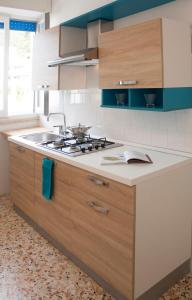 a kitchen with a sink and a stove top oven at Appartamento La Vela in Lido Conchiglie