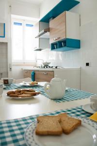 a kitchen with a table with bread and a teapot at Appartamento La Vela in Lido Conchiglie