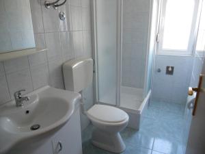 a bathroom with a toilet and a shower and a sink at Apartments Violeta in Betina +13 photos