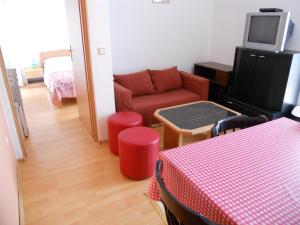 a living room with a red couch and a tv at Apartments Violeta in Betina