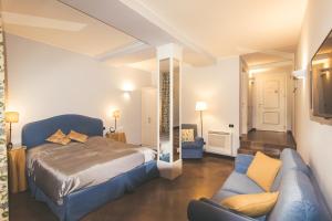 a bedroom with a bed and a couch in a room at La Valletta Relais in Bergamo