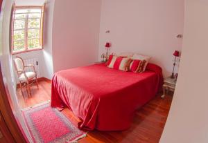 a bedroom with a red bed with a red blanket at Apartamento Tránsito de Entrerruas in Santiago de Compostela