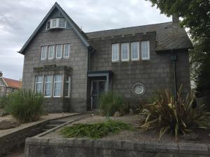una antigua casa de piedra con ventanas y plantas blancas en Aberdeen Serviced Apartments - The Lodge en Aberdeen