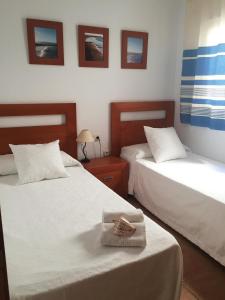 コティージョにあるCotillo Sea Homeのホテルルーム内のベッド2台 テーブルの上にタオルを用意しています。