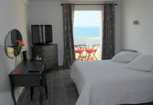 sypialnia z łóżkiem i telewizorem oraz balkonem w obiekcie Stella Maris w Hyères