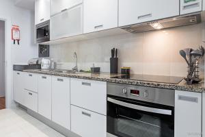 a kitchen with white cabinets and a counter top at Santa Catarina l by An Island Apart in Funchal