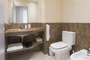 a bathroom with a toilet and a sink and a mirror at Santa Catarina l by An Island Apart in Funchal