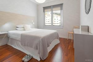 a white bedroom with a bed and a window at Santa Catarina l by An Island Apart in Funchal