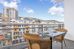 a table and chairs on a balcony with a view at Santa Catarina l by An Island Apart in Funchal