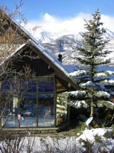 ein Haus im Schnee mit einem Weihnachtsbaum in der Unterkunft Les Tanneries in Villar-Saint-Pancrace