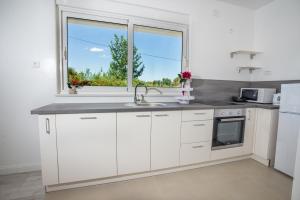 cocina blanca con fregadero y ventana en Apartments Duka, en Zadar