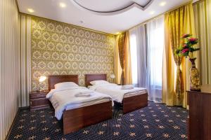 a bedroom with two beds and a wall with curtains at Hotel Golden Night in Kaliningrad