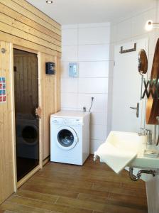 a laundry room with a washing machine and a sink at Reetdachhaus Strandecke in Freest