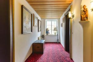 - un couloir avec de la moquette rouge et un plafond en bois dans l'établissement Schmied von Kochel, à Kochel am See