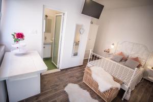 Habitación blanca pequeña con cama y mesa en Apartments Duka, en Zadar