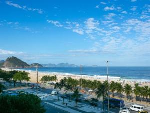 een uitzicht op een strand met palmbomen en de oceaan bij Deslumbrante vista para a Praia de Copacabana. in Rio de Janeiro