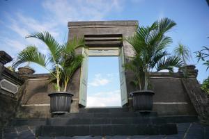 a building with two palm trees in pots on the stairs at Villa Gede Private Guest House in Selemadeg