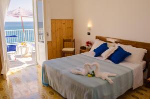 a bedroom with two towel animals on a bed at Hotel Angelino in Ischia +37 photos