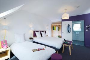 una camera d'albergo con due letti e un tavolo di ibis Styles Calais Centre a Calais