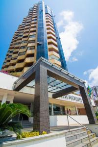 un edificio alto con una estatua delante de él en Golden Fortaleza by Intercity, en Fortaleza