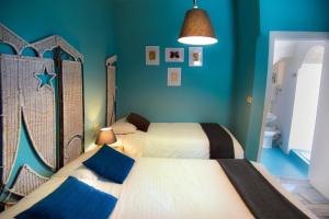 a bedroom with two beds with blue walls at Pensione Oliva in Lagonegro