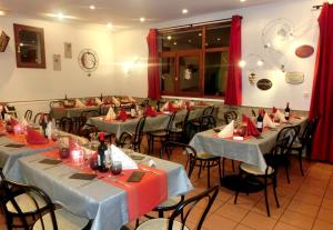 un comedor con mesas, sillas y cortinas rojas en VVF Saint-Lary-Soulan Hautes-Pyrénées, en Saint-Lary-Soulan