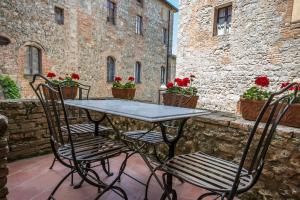 a table and chairs on a patio with flowers at Castel Pietraio in Monteriggioni
