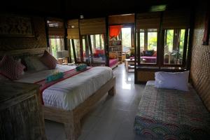 a bedroom with two beds and a living room at Villa Gede Private Guest House in Selemadeg +37 photos