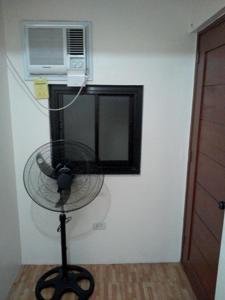 un ventilatore è su un supporto in una stanza di Budget Studio Unit in Makati a Manila