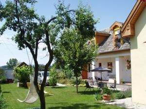 a tree with a hammock in the yard of a house at Rudolf's Fogadó in Zsira