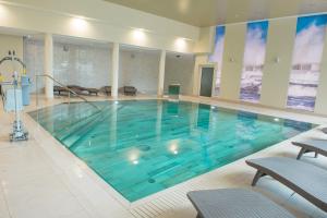 duży basen z błękitną wodą w budynku w obiekcie SeaPark Hotel Wellness & Spa w Kołobrzegu