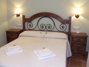 ein Schlafzimmer mit einem Bett mit zwei Handtüchern darauf in der Unterkunft Los Herrero in Zarzuela del Monte