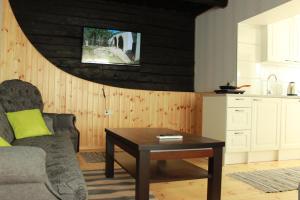 uma sala de estar com uma mesa e uma cozinha em Nurmeveski Holiday House em Nurme